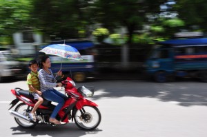 Woman and child on moped with umbrella, Luamg Prabang Laos (c) O.Boundy